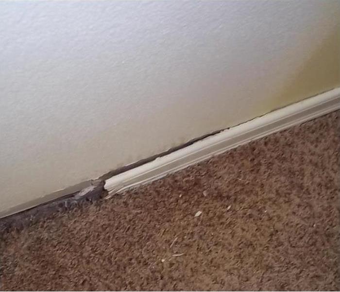 a picture of a saturated wall behind baseboard